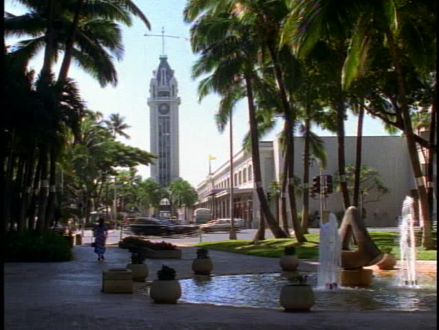 The Aloha Tower, with traffic and a fountain in Honolulu