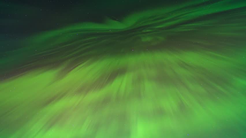 Dynamic northern lights forming a swirling spiral pattern in the night sky above Minnesota, USA.