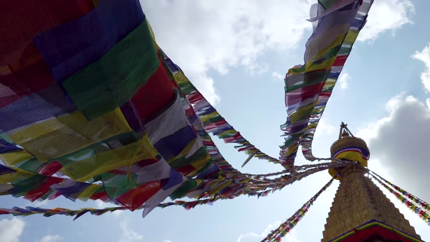 Lines of prayer flags blowing in the wind at the Boudhanath stupa temple in Kathmandu, Nepal - Silhouette view