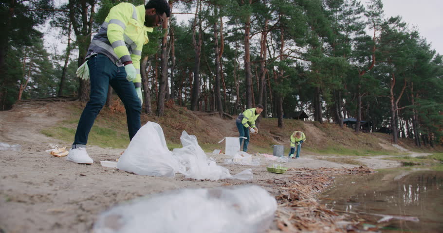 Group of people completing important task. Working in clean up crew for big hotel or resort. Cleaning up polluted area with plastic waste material. Preparing beach for next season.
