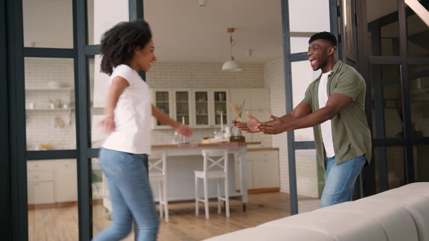 African American love couple happy family meeting at home woman jumping man hugging spinning together laugh affection embrace cuddle closeness girl guy lovers bonding celebrate wedding propose engaged