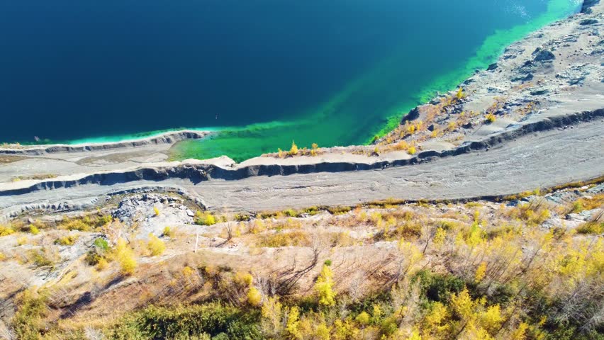 Aerial top-down view of Black Lake with turquoise waters and autumn hues