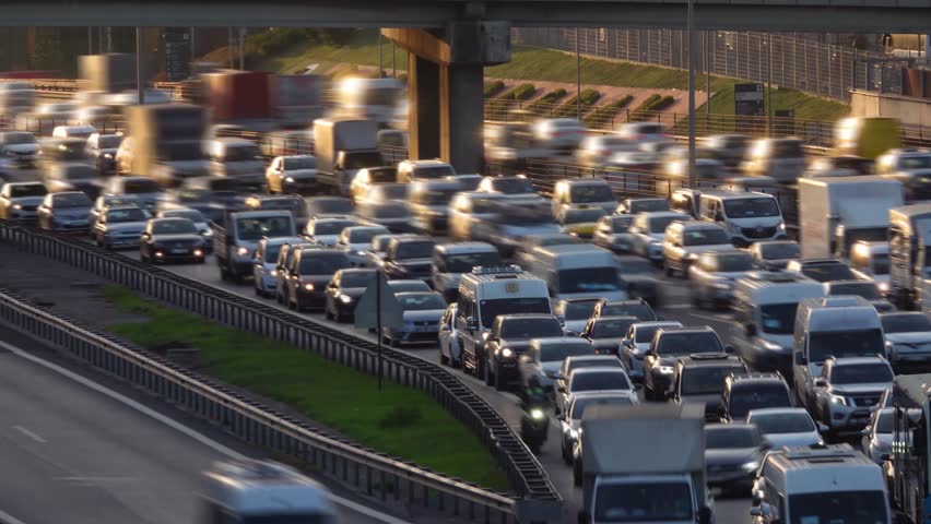 City traffic time lapse in sunset. City traffic at rush hour. Heavy day traffic. Blurred background and glittering chaos. Unrecognizable cars with motion blur effect. 