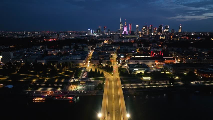 Swietokrzyski Bridge over the Vistula River with a panoramic view of the center of Warsaw at night Poland. Drone Footage.