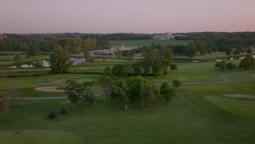 Aerial of golf course with the Grand Basin and Art Museum in the background in St. Louis, Missouri on a pretty evening. Camera slides right.