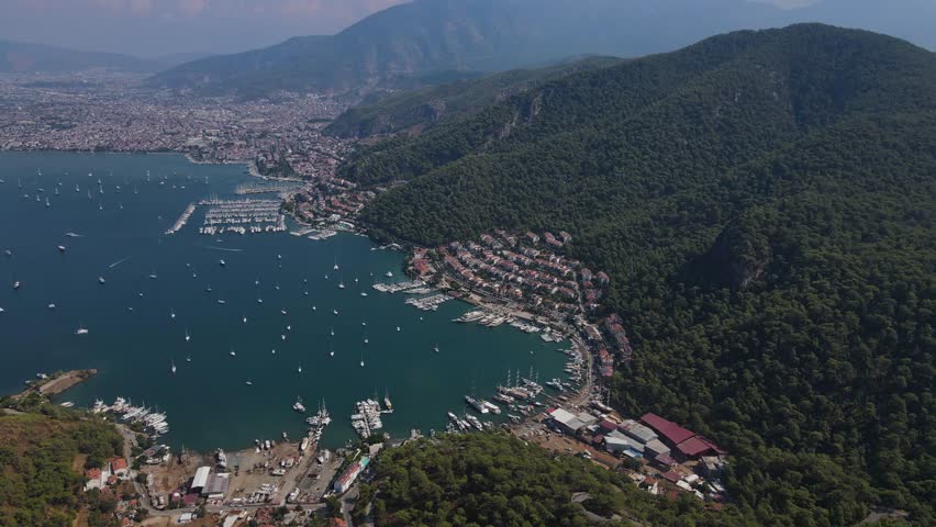 Aerial shot: beautiful view of the city with a large bay in Turkey. The bay is full of boats at anchor and the water is calm.