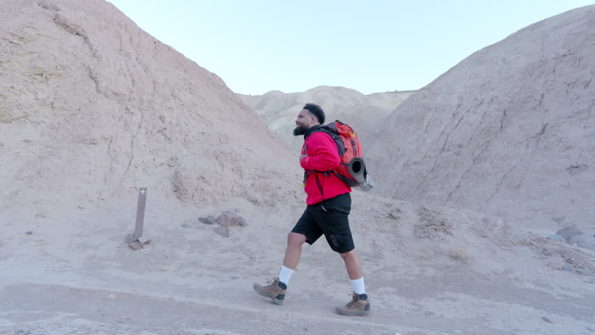 A dedicated traveler skillfully navigates through the stunning and diverse landscapes of Death Valley National Park, beautifully showcasing the unique beauty found in desert hiking experiences
