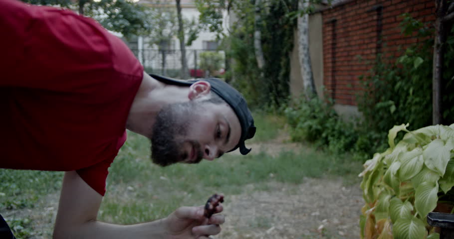 Friends enjoying a barbecue in a rustic backyard. They are eating, drinking, and having fun together.