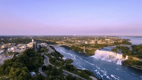 Scenic aerial view of Niagara Falls and surrounding urban cityscape at sunset. The flowing water contrasts with the serene pink and blue sky, creating a breathtaking panorama, Canada, zoom out - Powered by Shutterstock - Get 15% off with code: PIKWIZARD15
