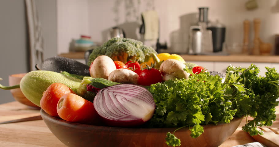 Colorful assortment of fresh vegetables displayed in a wooden plate, highlighting a healthy variety of produce.