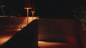 A serene nighttime scene featuring modern outdoor lighting. Two stylish orange lamps illuminate a curved concrete pathway, creating a warm ambiance. The surrounding area is dark, enhancing the glow  - Powered by Shutterstock - Get 15% off with code: PIKWIZARD15