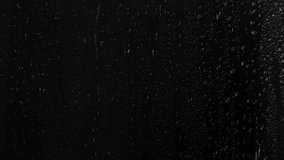 Closeup water rainfall, rain drops falling on window glass over black background - Powered by Shutterstock - Get 15% off with code: PIKWIZARD15