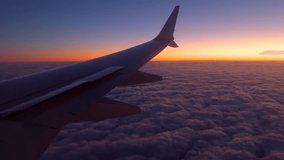 Airplane Wing Above Clouds During Vibrant Sunset at High Altitude. High quality 4k footage - Powered by Shutterstock - Get 15% off with code: PIKWIZARD15