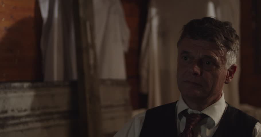 Portrait of an old-timey doctor sitting in a cabin the prohibition era