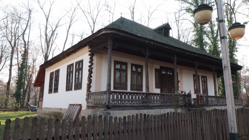 A well-preserved traditional Romanian house with a wooden porch and intricate details, located in Bucharest