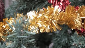 Gold tinsel and glittery pinecone decoration on a Christmas tree in Alicante, Spain - Powered by Shutterstock - Get 15% off with code: PIKWIZARD15
