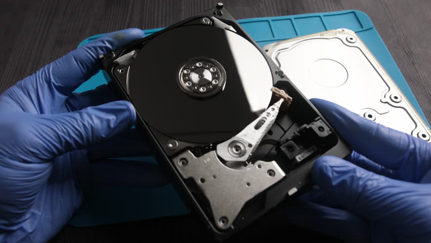 repairman fixing computer hard disk drive in service center