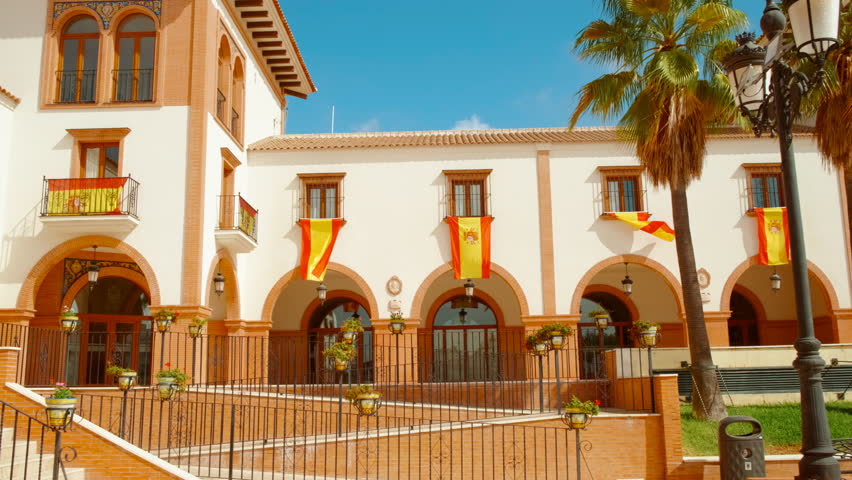 Plaza de Espana in Palos de la Frontera, Huelva, Andalucia, Spain, adorned with Spanish flags, radiates national pride and history