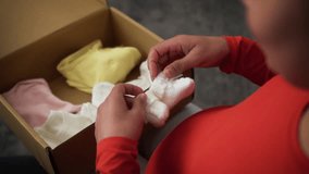 Pregnant woman African female girl lady mother pregnancy open cardboard parcel box order shopping online child kid clothes preparing to baby medicine holding little tiny baby shoes socks put on belly - Powered by Shutterstock - Get 15% off with code: PIKWIZARD15