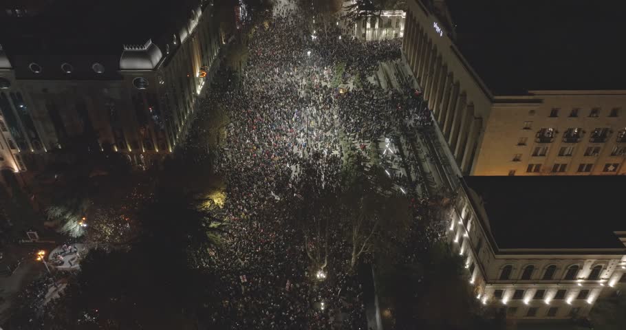aerial drone shot of manifestation. People protesting Protest in country Georgia, Tbilisi to Government for suspending relationships with EU. Crowd of people. Translation: Rebel and go on strike