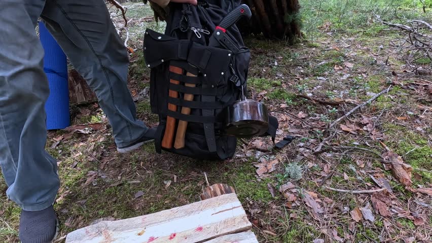 A tourist packs a backpack in the forest