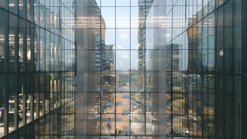 Aerial view of Windows in a high-rise office building early morning with interior lights glowing. Corporate offices.Night view Skyscraper with night lights and empty offices