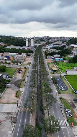 A vertical video capturing Avenida Mario Covas Jr in Arujá, Alto Tietê, São Paulo, showcasing the busy street, traffic, and suburban cityscape of this Brazilian area