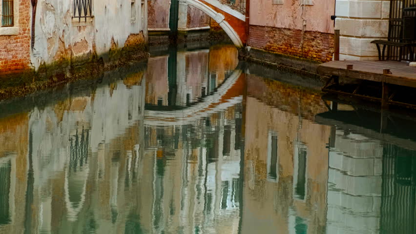 Stunning view of one of the famous canals in Venice, Italy along with quirky buildings, powerful reflections and vivid green water. Venice is an archipelago of 126 islands linked by 472 bridges