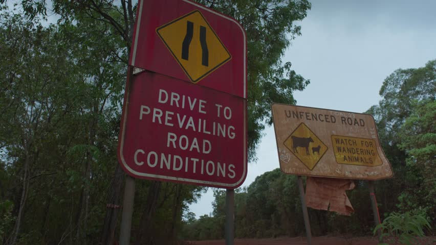 Old road warning sign on a gloomy overcast day. Slow left to right movement.