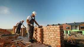 Two Builders Laying Bricks at Construction Site - Powered by Shutterstock - Get 15% off with code: PIKWIZARD15
