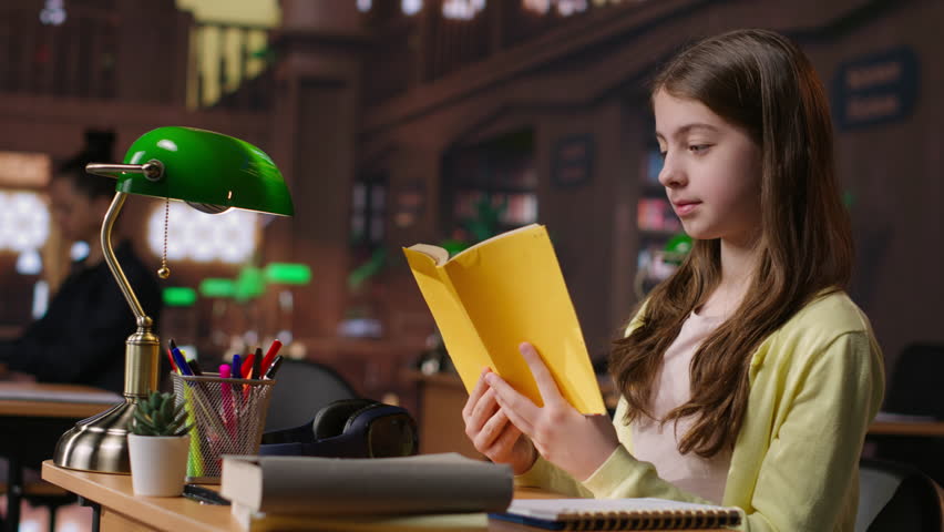 Teenager immersed in reading literary works from the school library database, focusing on her education and preparing for mandatory assignments or lectures. Diligent girl loves to read. Camera B.