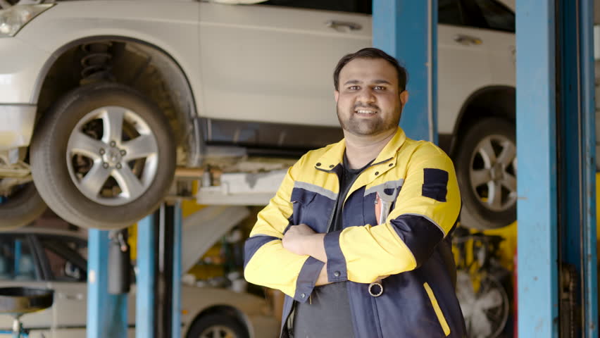 Mechanic, face and arms crossed with asian man and car in auto repair shop for diagnostic, transport or calibration. Engineering, maintenance or motor technician with portrait of person in garage