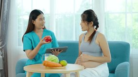 Utiful female nutritionist uses a tablet to introduce foods, fruits such as apples, to young pregnant Asian woman with a potbelly. The pregnant woman consults a medical nurse about improving her diet - Powered by Shutterstock - Get 15% off with code: PIKWIZARD15