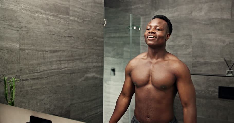 Black man, mirror and muscle power in bathroom for fitness, results and confidence with progress and abs in home. African person, reflection and strong body for exercise, pectoral flex and wellness