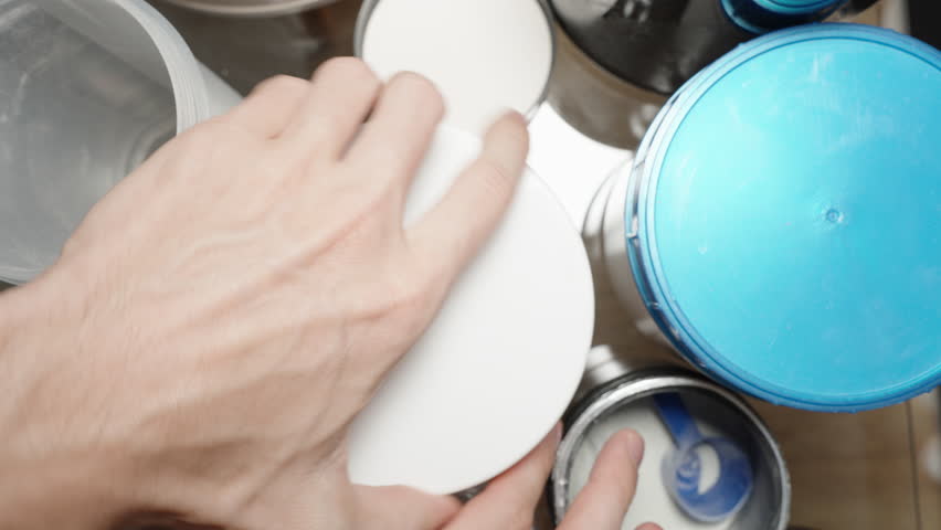 Pouring Creatine back into the jar and closing the lid, reconsidering its use in the workout routine.