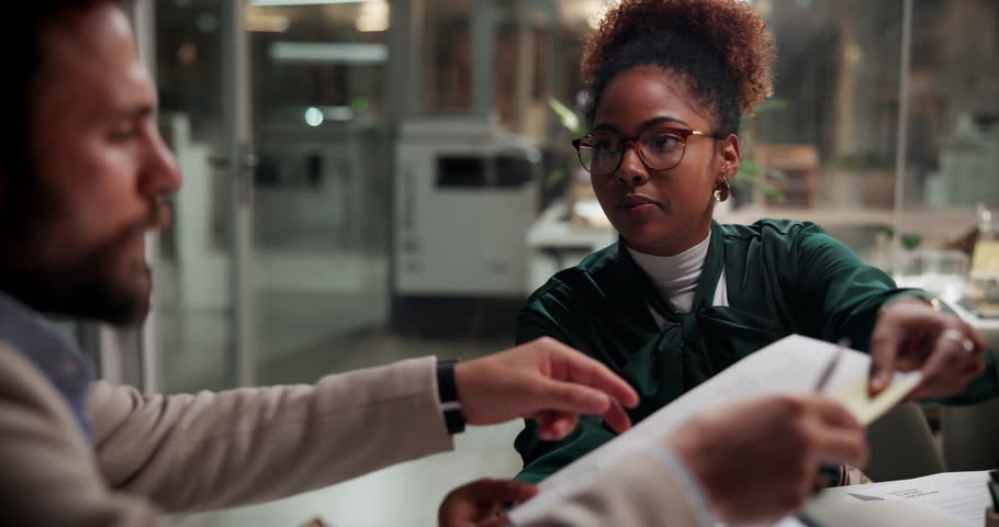 Business people, team and planning in meeting with paperwork for media press release, pr or brand image. Collaboration, discussion and manager giving document on overtime in creative startup at night