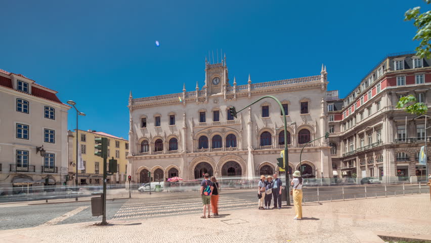 Rossio station in Lisbon timelapse hyperlapse. Front view with zebra crossing and street traffic. 19th century railway building located at Don Pedro IV Square. Portugal.