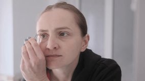 Woman plucking her eyebrows with tweezers, showcasing beauty and grooming routines - Powered by Shutterstock - Get 15% off with code: PIKWIZARD15