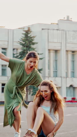 Cool Young Girls Longboards and Skateboards Through Stylish Hip Cultural Part of the City. Skateboarding Down the Road in the Hipster District. Concept of love, vintage, woman friendship