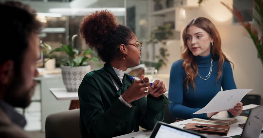 Business people, group and planning in meeting with paper for media press release, pr strategy and brand image. Team, discussion and manager giving document on overtime in creative startup at night