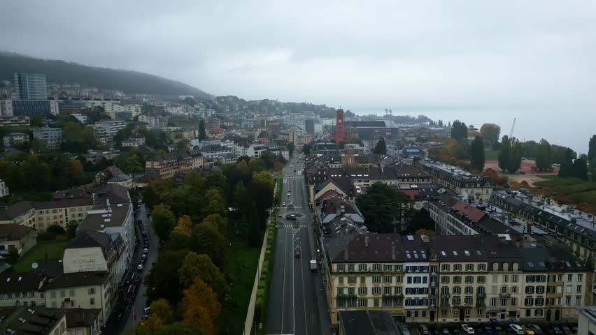 Push in drone shot of Neuchatel cityscape with moody weather in Switzerland