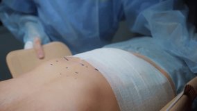 A skilled surgeon carefully puts a corset on a patient after a procedure at a medical facility. The patient is prepared for support and recovery needs following surgery. - Powered by Shutterstock - Get 15% off with code: PIKWIZARD15