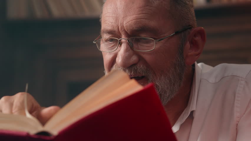 Caucasian old man reading book textbook hobby home library male businessman grandfather mature ready reader pensioner senior novel professor literature glasses health interest business office inside