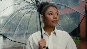 Successful African American woman looking at camera smiling worker holding umbrella rain female girl businesswoman business city leader employer entrepreneur boss standing outdoors lady rainy weather - Powered by Shutterstock - Get 15% off with code: PIKWIZARD15