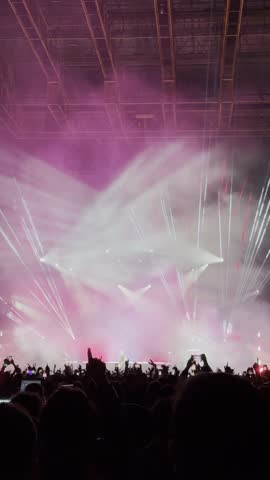 People celebrating music concert. Vertical footage. The silhouettes of the crowd create an energetic and vibrant atmosphere. 