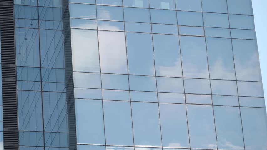 A Modern Glass Building Facade Reflecting the Beautiful Clouds and Vibrant Skyline
