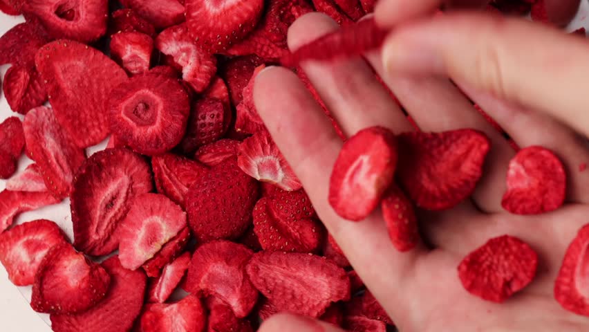 strawberry crisps, rotation in circle. dehydrated strawberries, Turning. Freeze-dried strawberries. Holding red dried strawberries in your hands