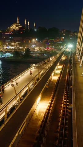 Istanbul night city view, Turkey, train at metro station on bridge over Golden Horn Bay, at night, arrival or departure
