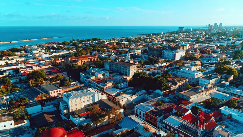 Evening view of beautiful cityscape on the shore of blue Caribbean sea. City on the coast of Atlantic ocean. City and sea 4k background. Santo Domingo Dominican Republic.