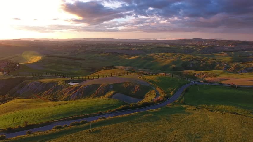 Tuscany aerial landscape with road and cypresses of farmland hill country at sunset. Italy, Europe, panorama 4k